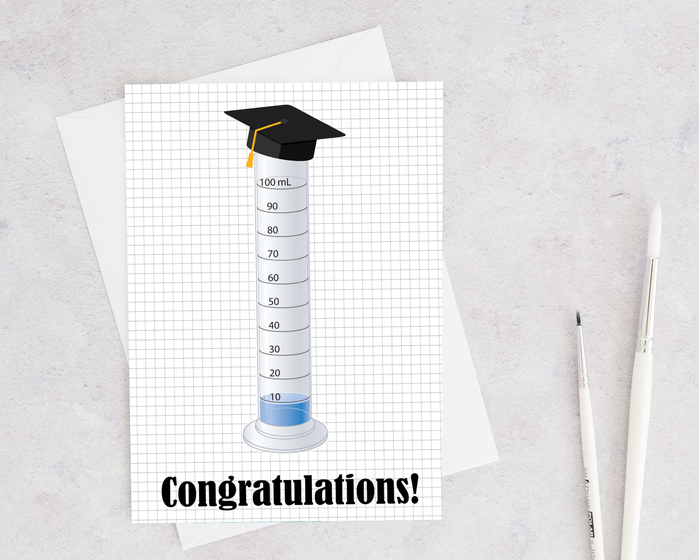 graduated cylinder with a graduation cap to say happy graduation to a scientist or chemist
