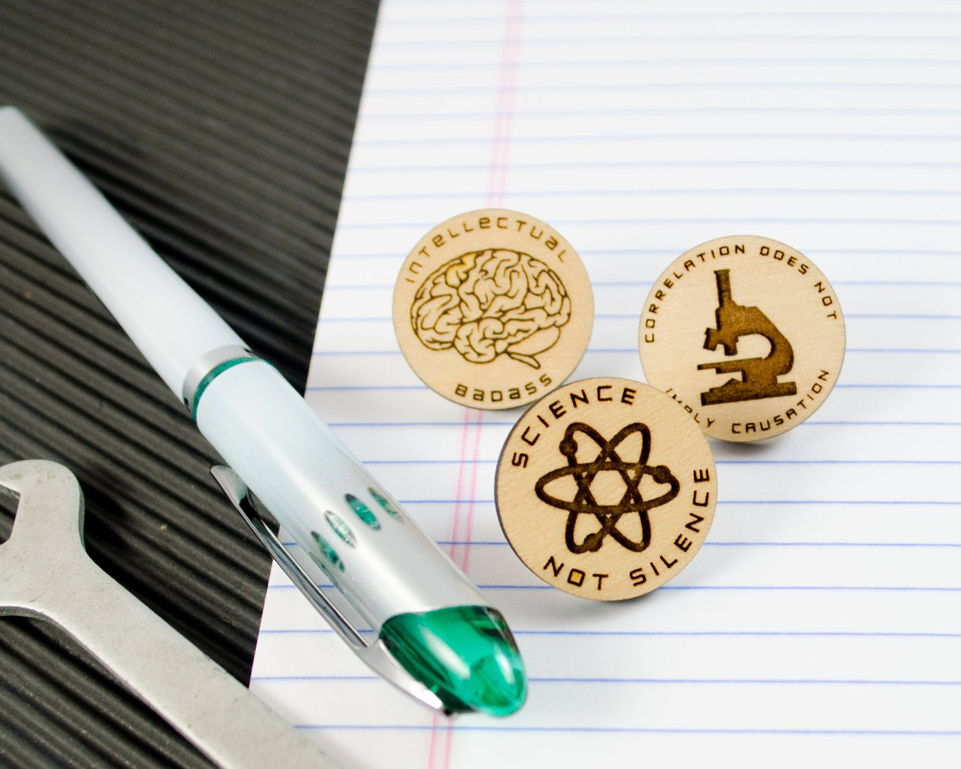 set of three wood science pins with brain, atom, and microscope