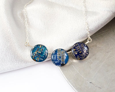three different shades of blue circuit board made into a hand fabricated sterling silver necklace