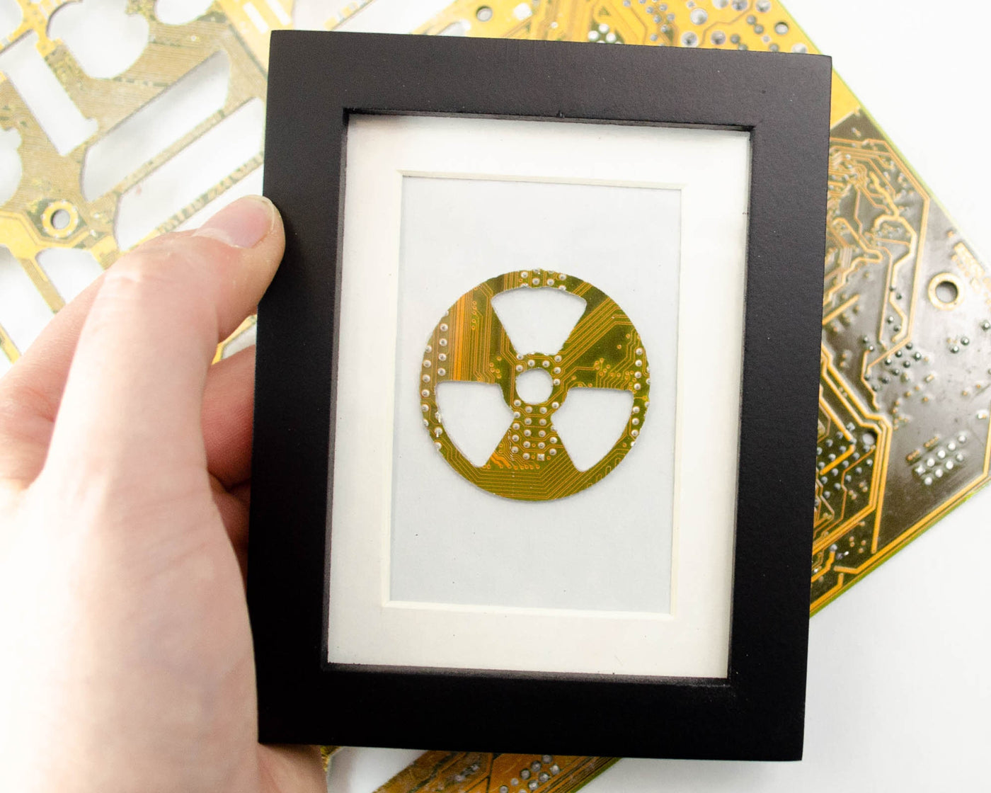 handmade recycled circuit board art shaped like radiation symbol and framed